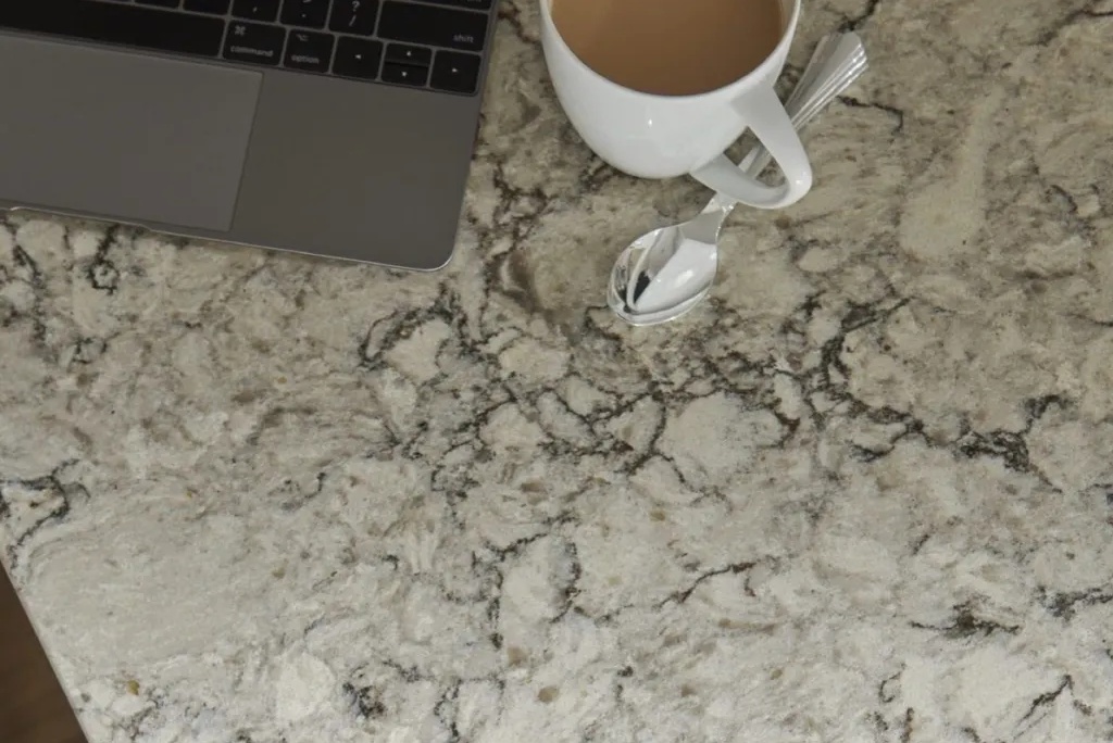 closeup shot of a spoon, a cup of coffee, and a laptop