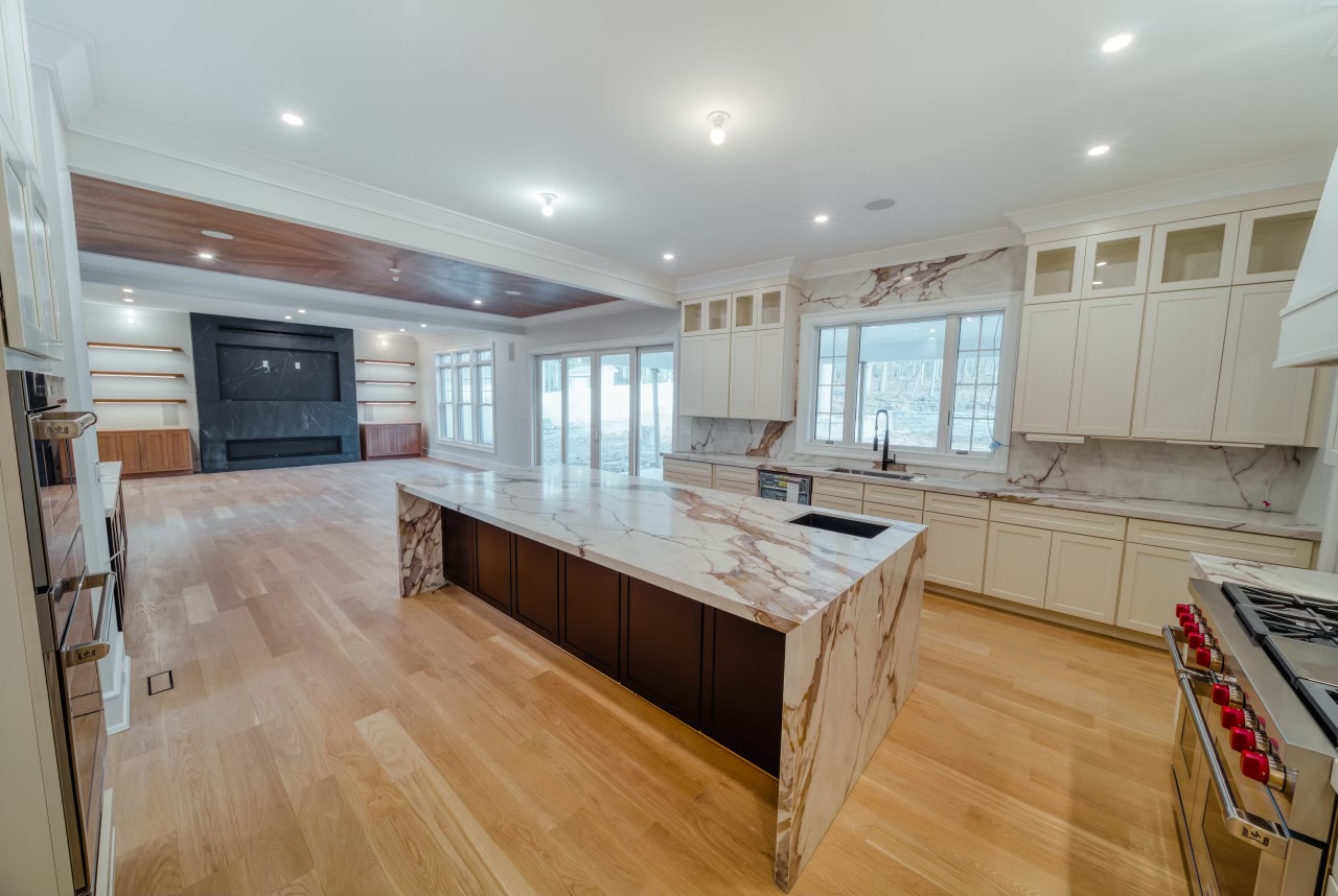 a kitchen area with white marble countertop and cabinets