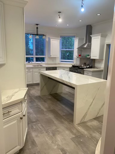 a kitchen area with a cream colored marble countertops
