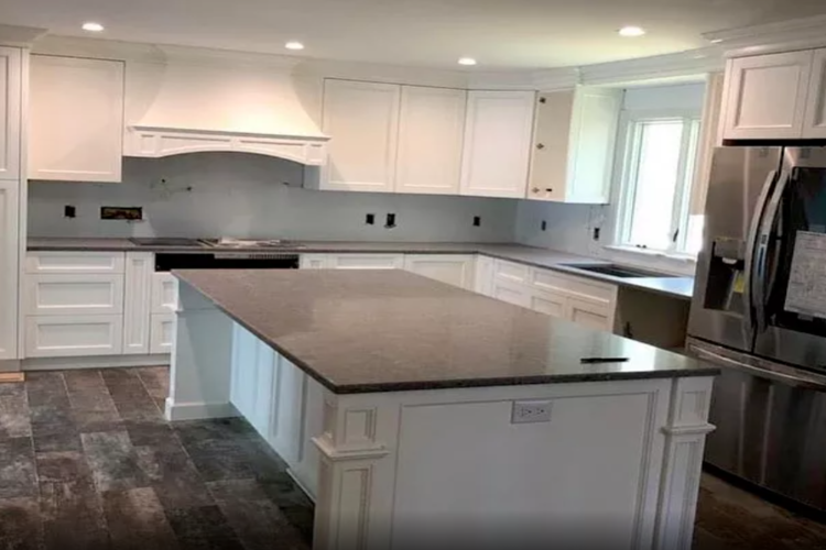 a kitchen island with a black marble countertop
