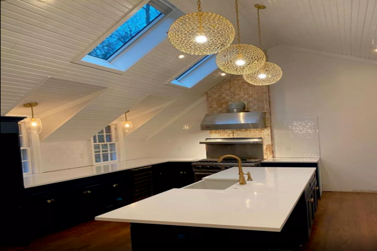 a black and white kitchen island with lights above it
